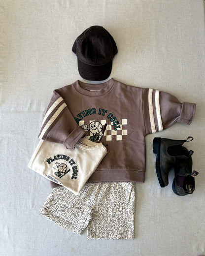 Flat lay of the Elmo Shorts with the Alvin Cool Sweatshirt, Sommer Cool T-shirt, Kamma Cap and black boots
